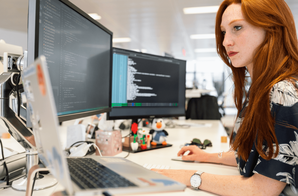 A woman working on a desktop computer in an office
